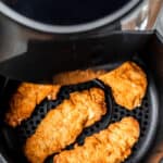 Air fried chicken tenders in the basket of an air fryer with text overlay.