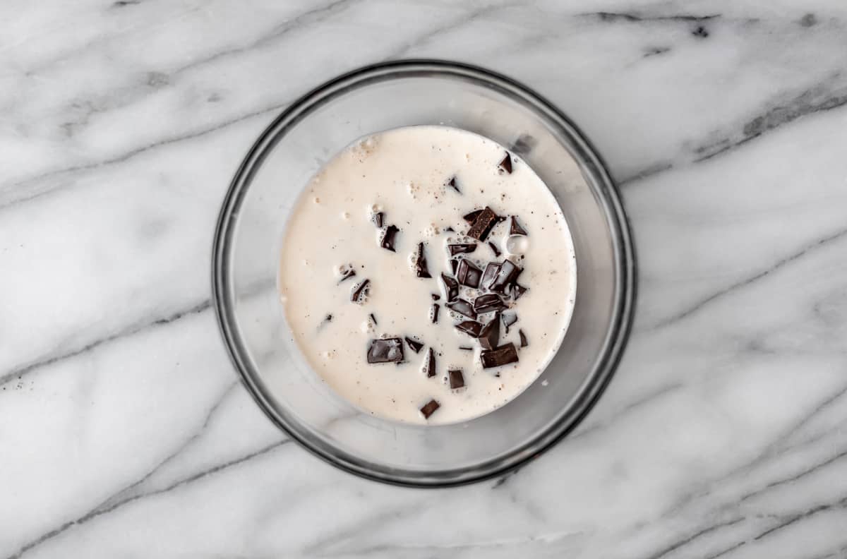 Chocolate chips and heavy creamy in a glass bowl.