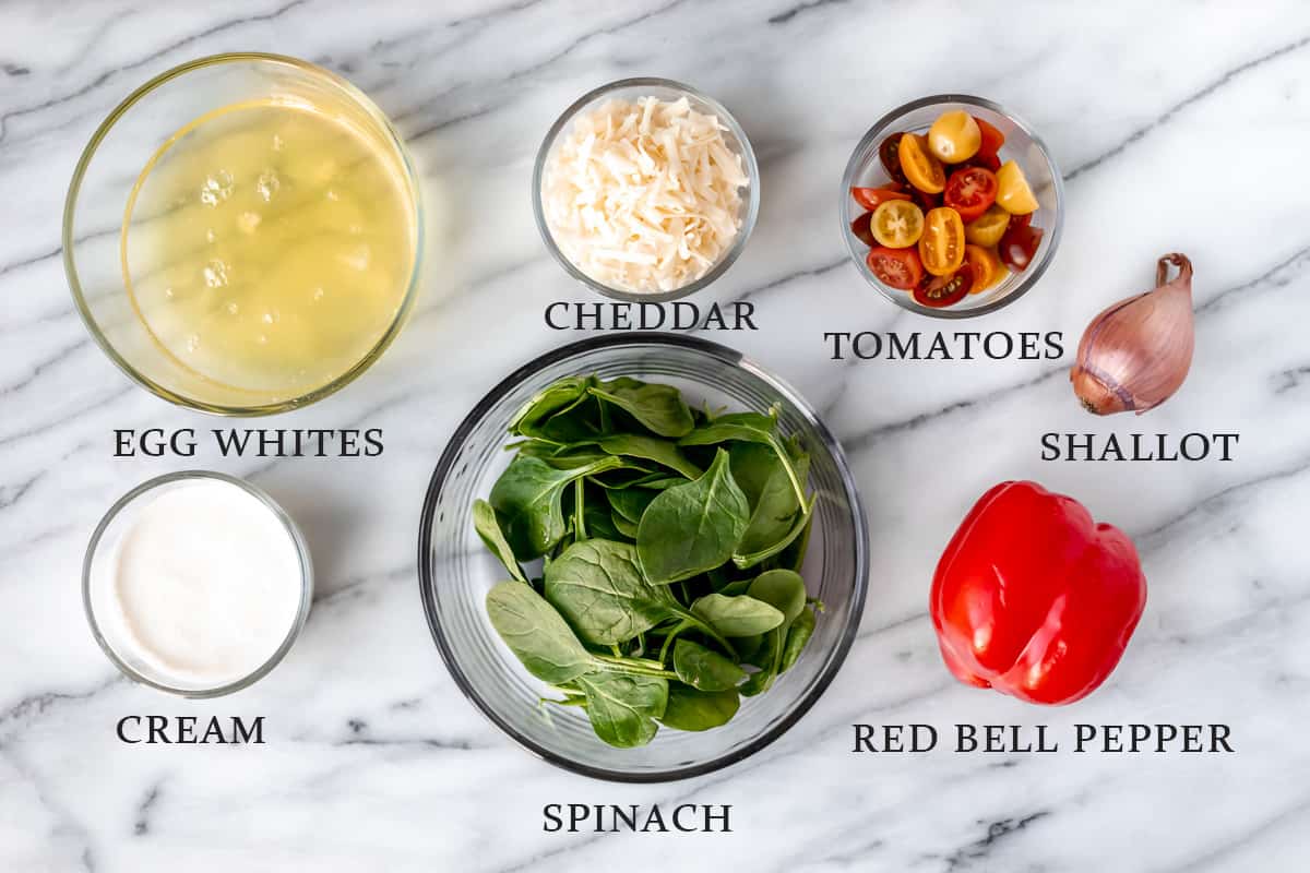 Ingredients needed to make an egg white frittata on a marble background with text overlay.