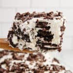 A serving of Oreo icebox cake on a wood server with text overlay.