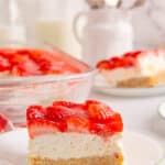 A slice of strawberry delight with a second serving and baking dish in the background with text overlay.