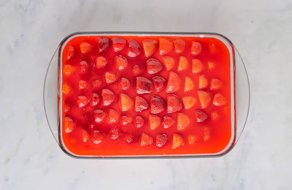 Strawberries on top of cheesecake filling topped with Jello.