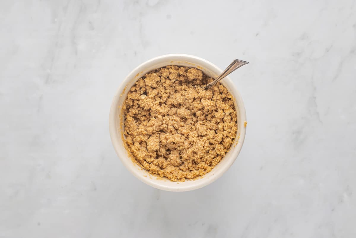 Graham cracker crust in a bowl with a spoon.