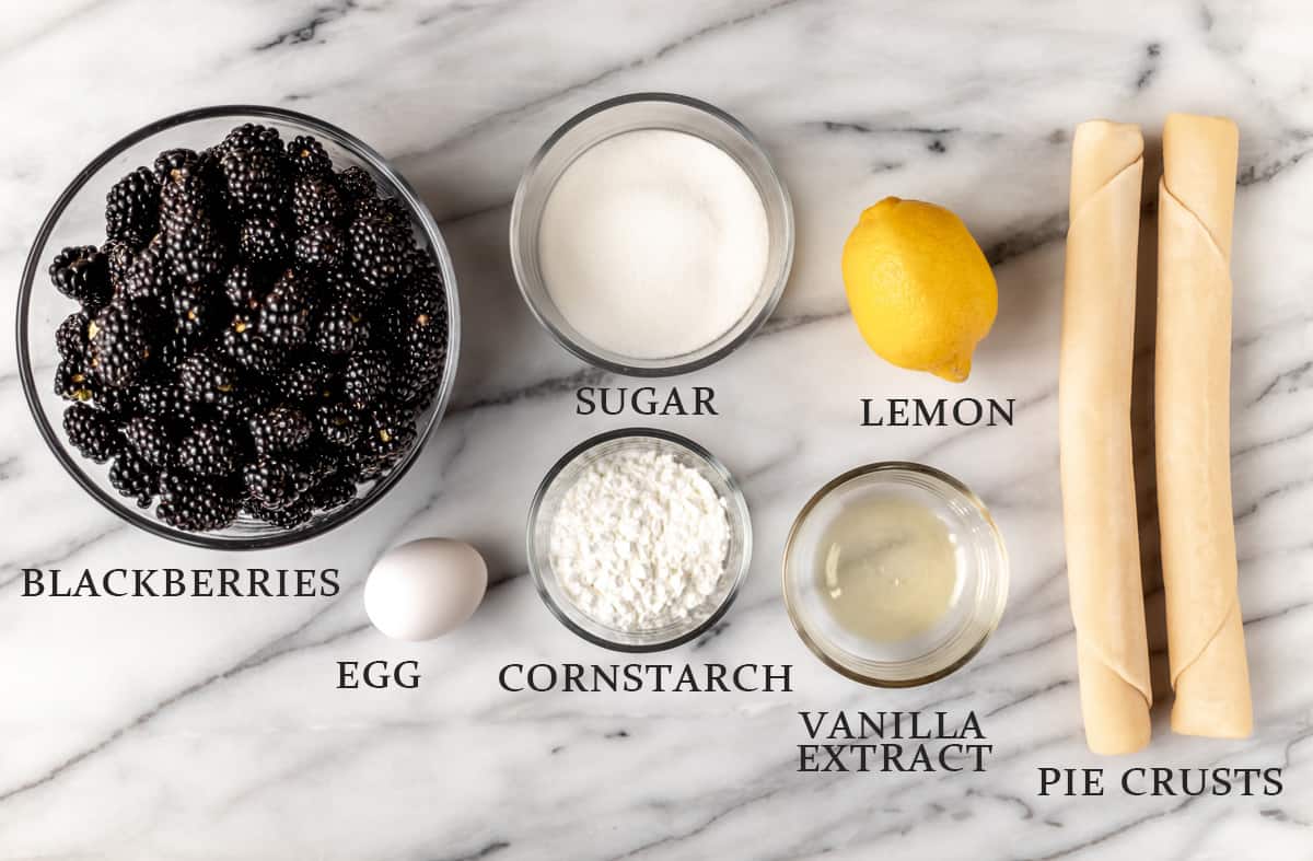 Ingredients to make a blackberry pie on a marble background with text overlay.