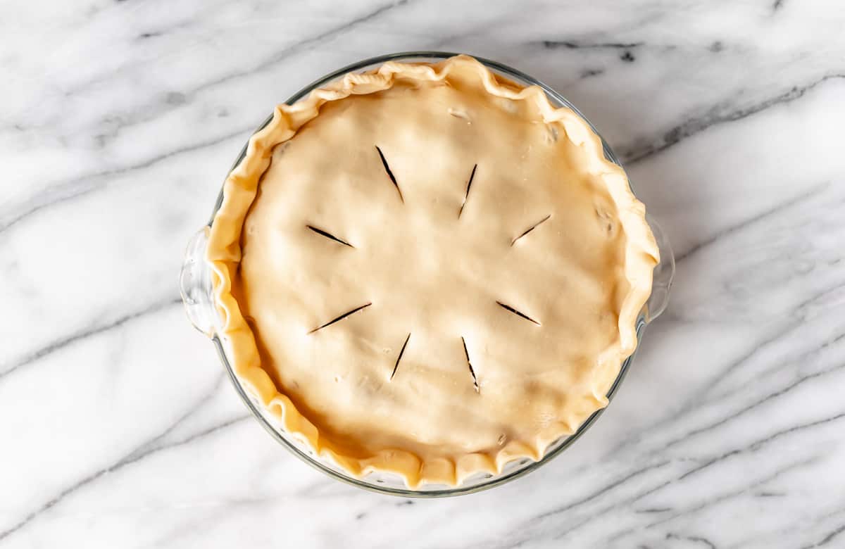 An unbaked pie on a marble background.