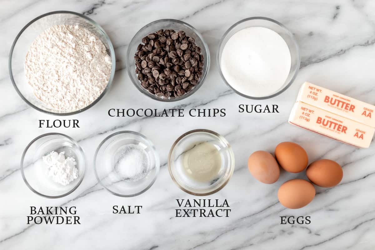 Ingredients needed to make a chocolate chip pound cake on a marble background with text overlay.