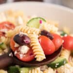 Greek pasta salad with text overlay.