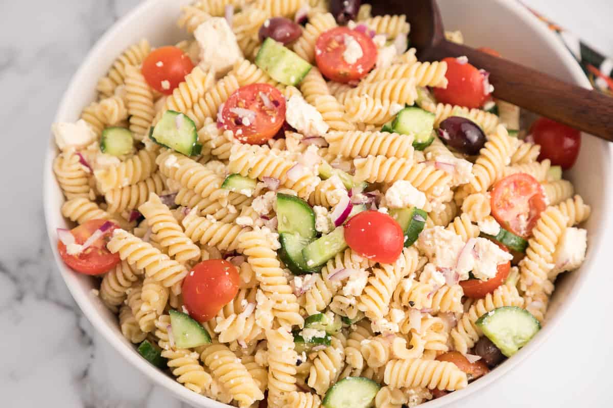 Greek pasta salad mixed together in a bowl.