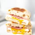 Two halves of a ham, egg and cheese breakfast sandwich with text overlay.
