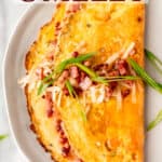 Close up of a ham and cheese omelet with text overlay.