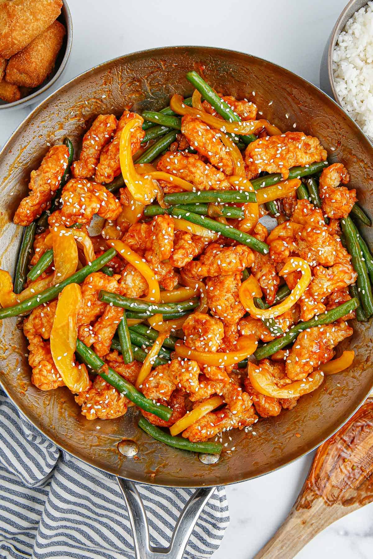 Panda Express copycat Honey Sesame Chicken in a skillet with green beans and peppers.