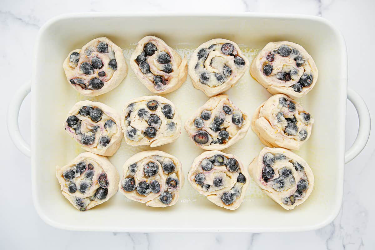 12 unbaked sweet rolls in a baking dish.