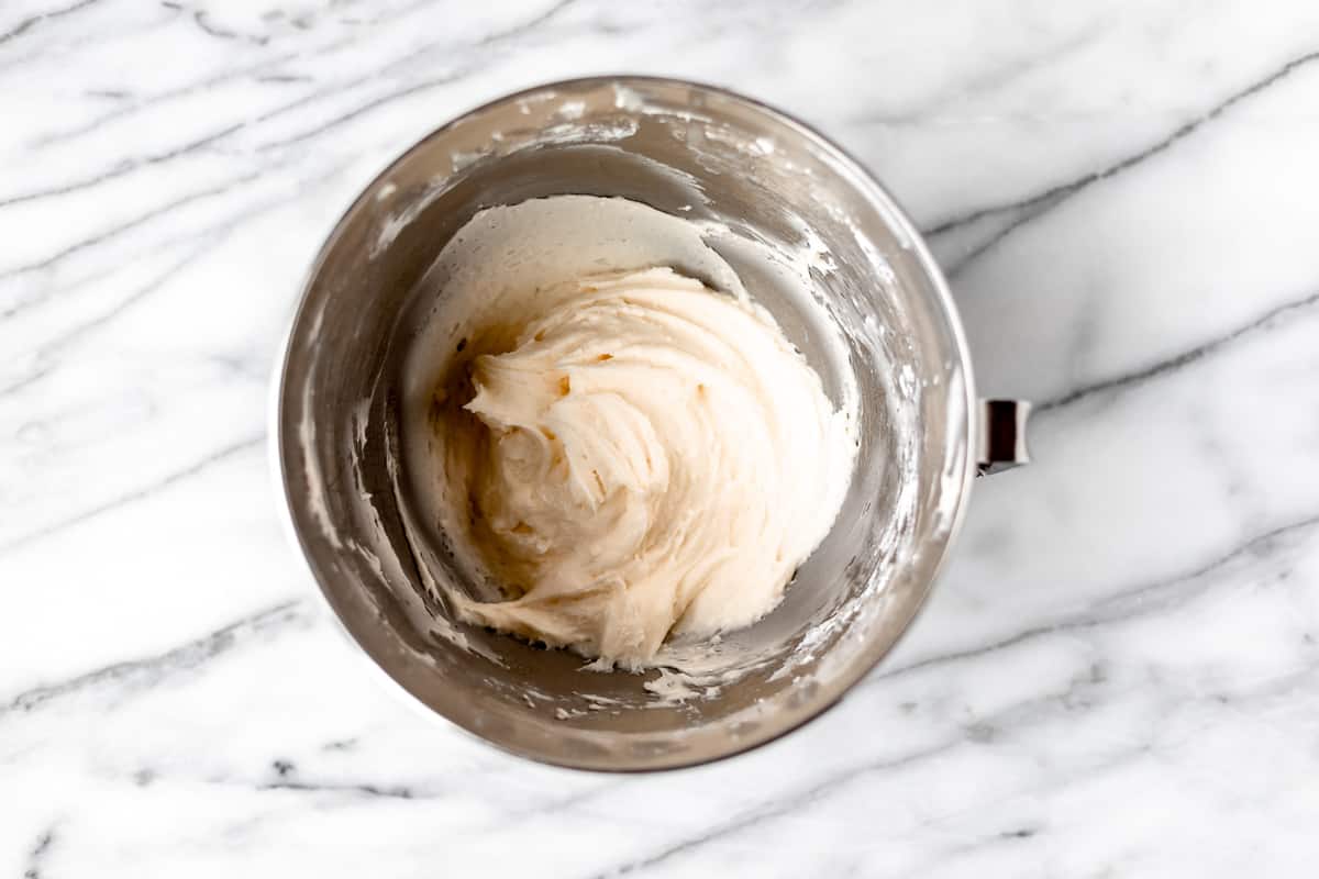 Vanilla buttercream frosting in a silver mixing bowl.