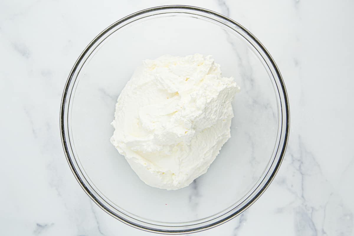 Whipped heavy cream in a glass bowl.