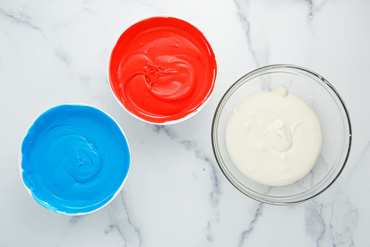Ice cream colored red, white and blue in 3 separate bowls.