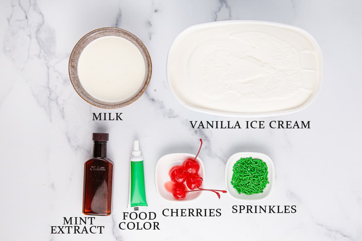 Ingredients needed to make a Shamrock Shake on a marble background with text overlay.