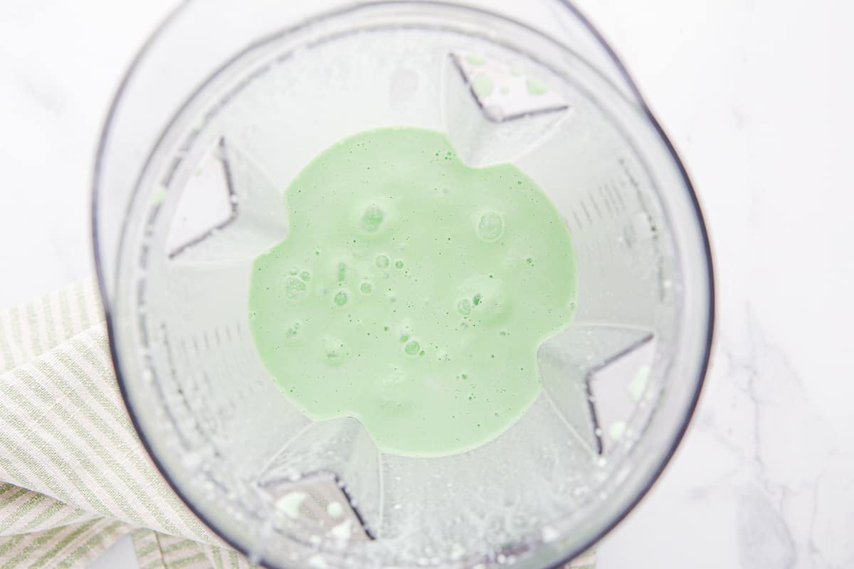 Shamrock shake in the bottom of a blender canister.