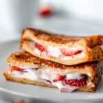 Stacked halves of strawberry stuffed french toast with text overlay.