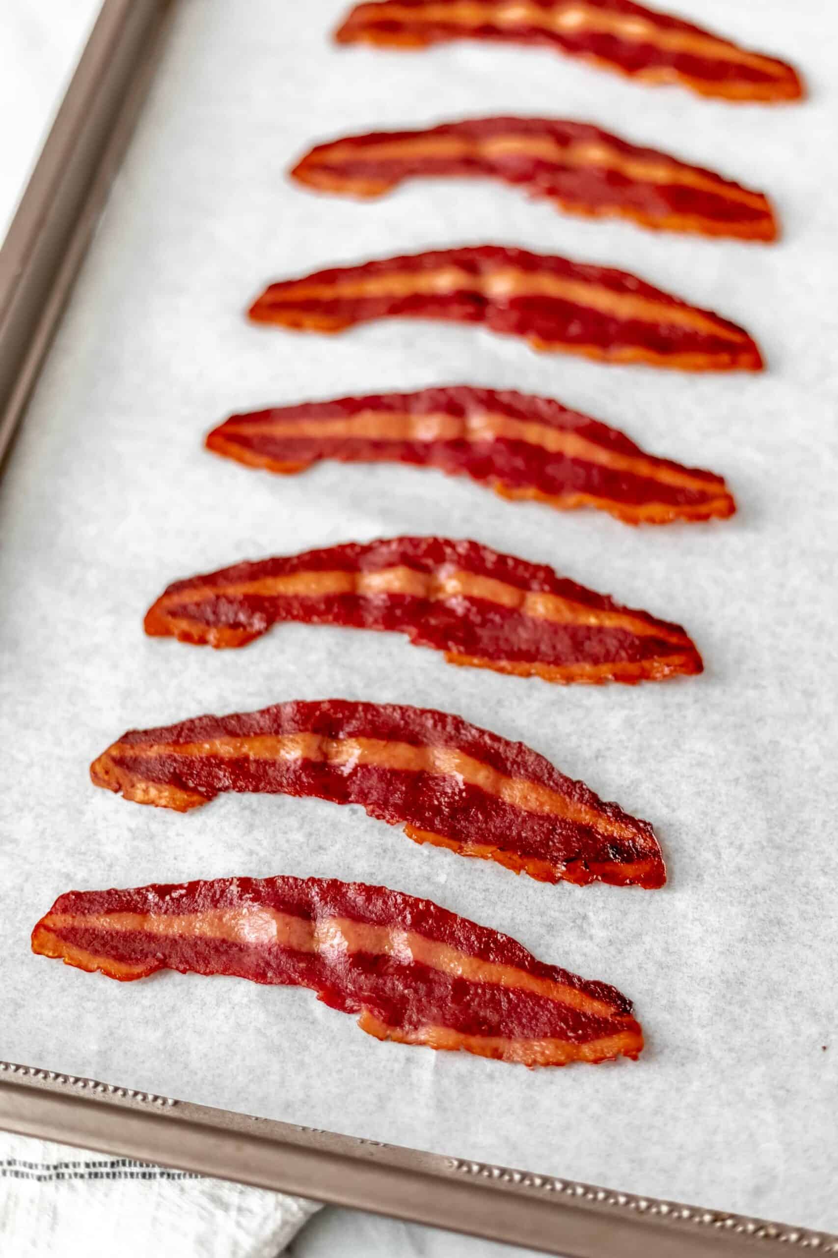 Baked turkey bacon on a parchment paper lined baking sheet.