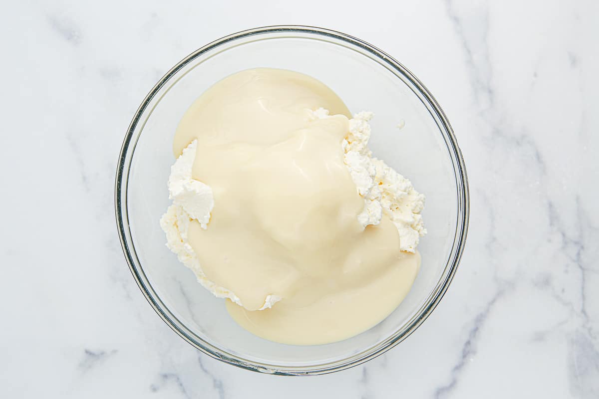 Whipped cream and condensed milk in a glass bowl.