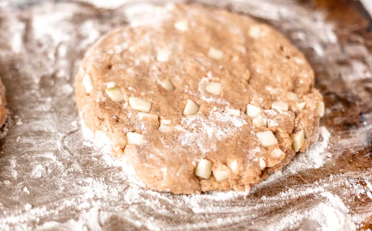 Apple cinnamon scone dough shaped into a disk.