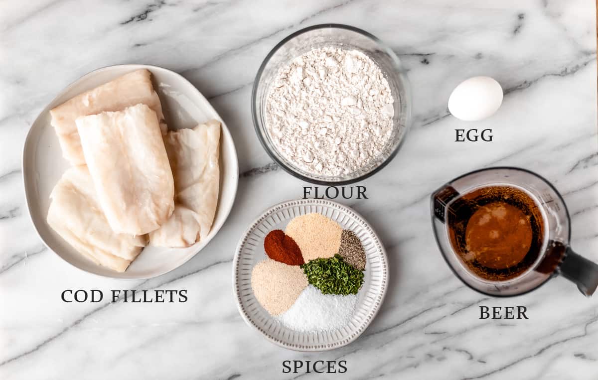 Ingredients needed to make beer battered cod on a marble background with text overlay.