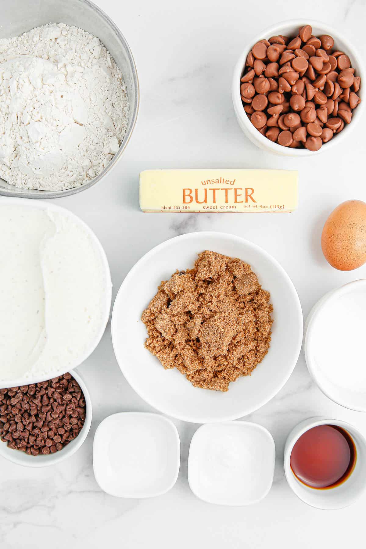 Ingredients needed to make chocolate chip ice cream sandwiches on a white background.