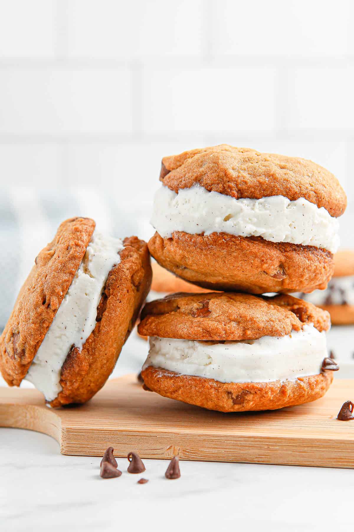Three cookie ice cream sandwiches on a plate.