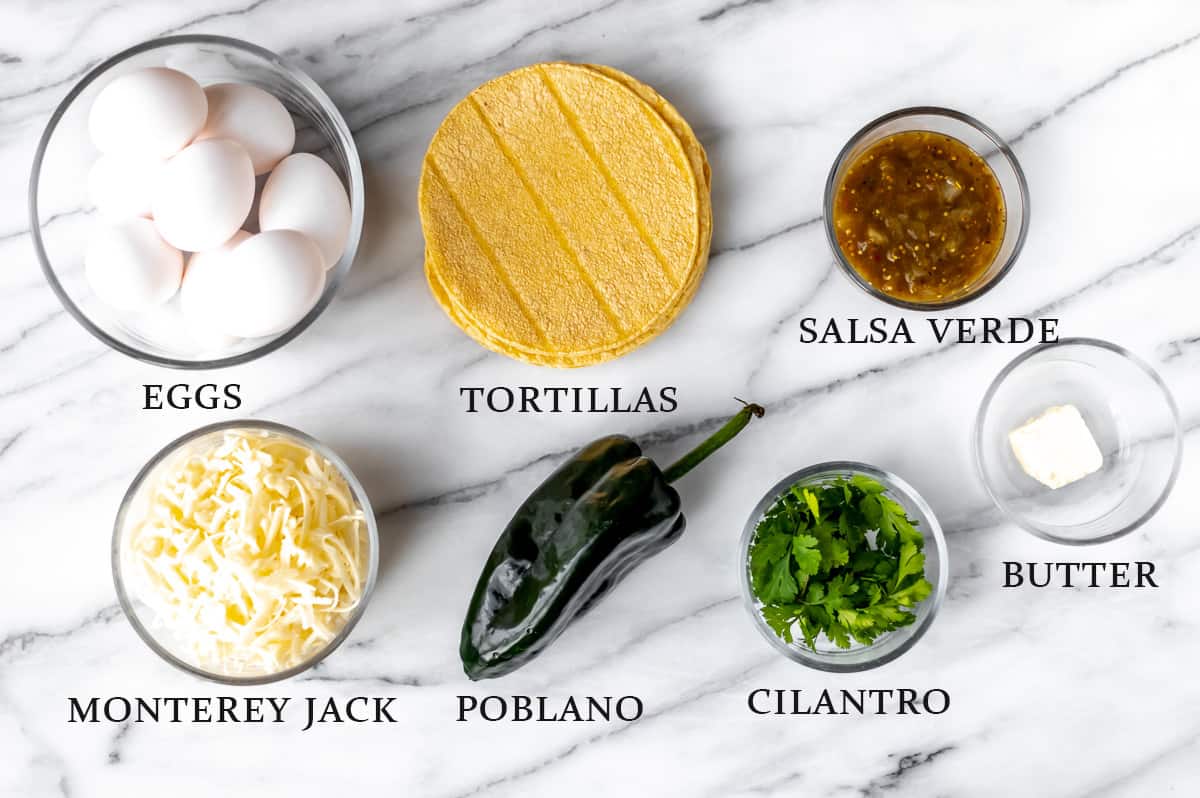 Ingredients needed to make migas on a marble background with text overlay.