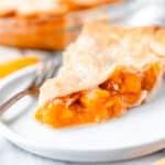 A slice of apricot pie on a white plate.
