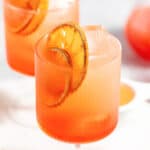 Blood Orange Aperol Spritz with dehydrated oranges with text overlay.