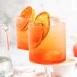 Blood Orange Aperol Spritz with dehydrated oranges with text overlay.