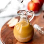 A cruet of apple maple vinaigrette with text