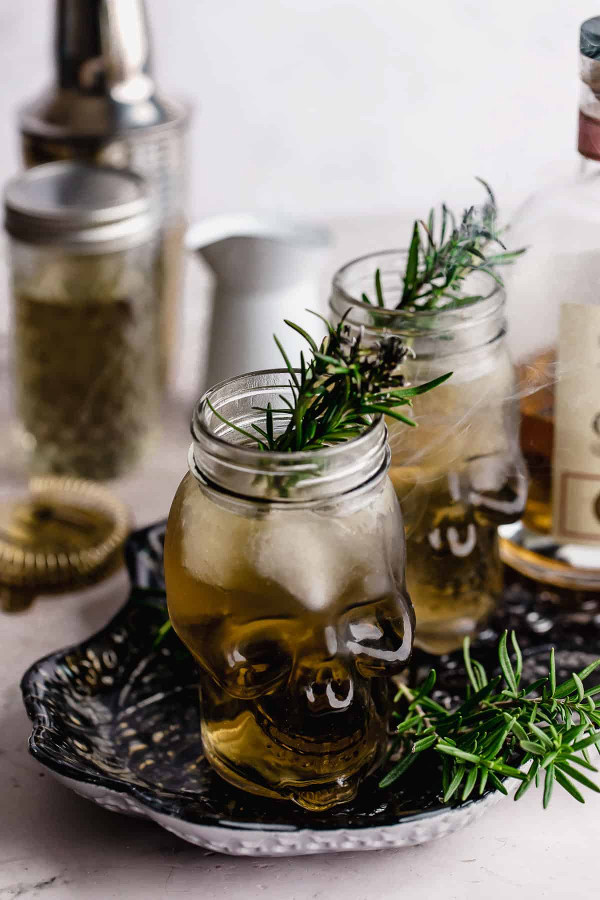 Two grave digger cocktails with smoking rosemary garnish.