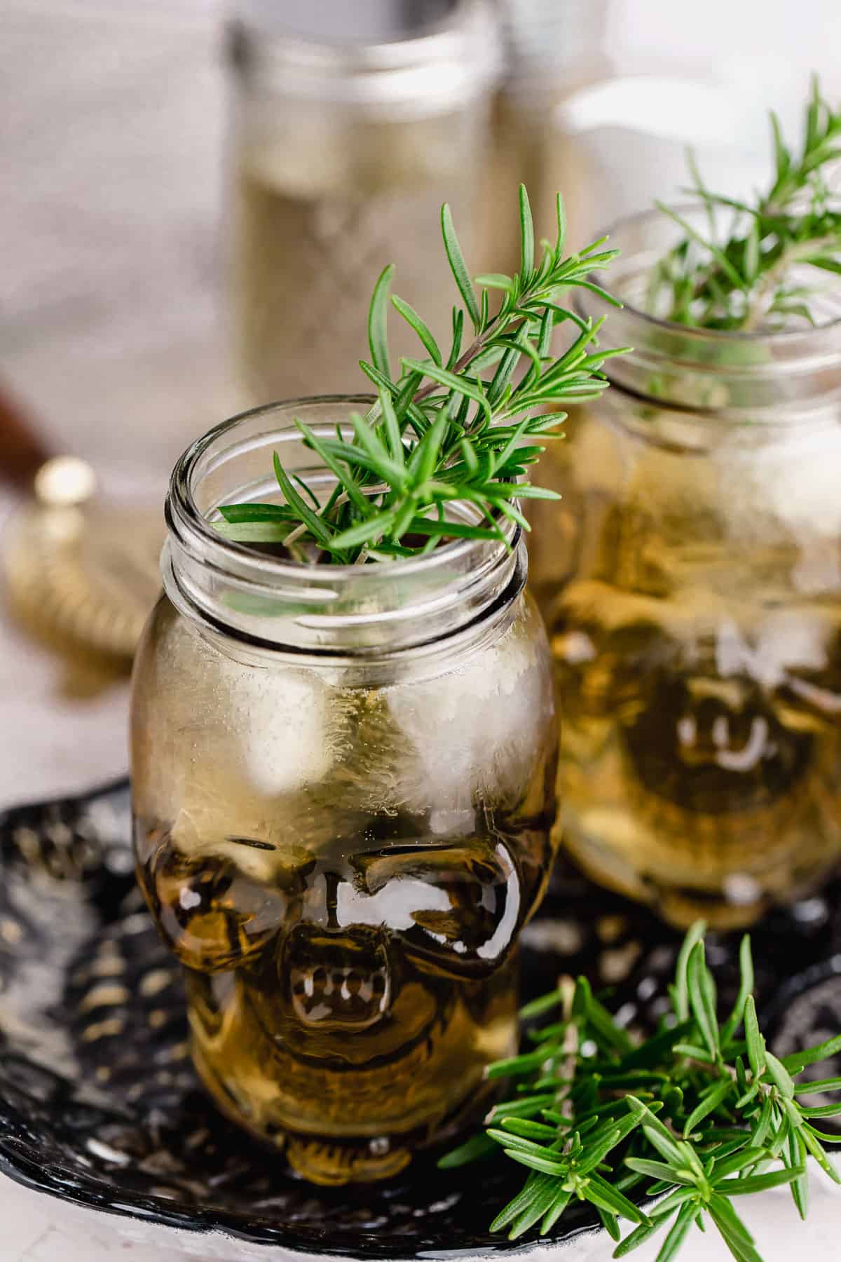 Close up of two grave digger cocktails with rosemary garnish.