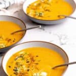 Instant pot carrot soup in a bowls with a spoons with text overlay.