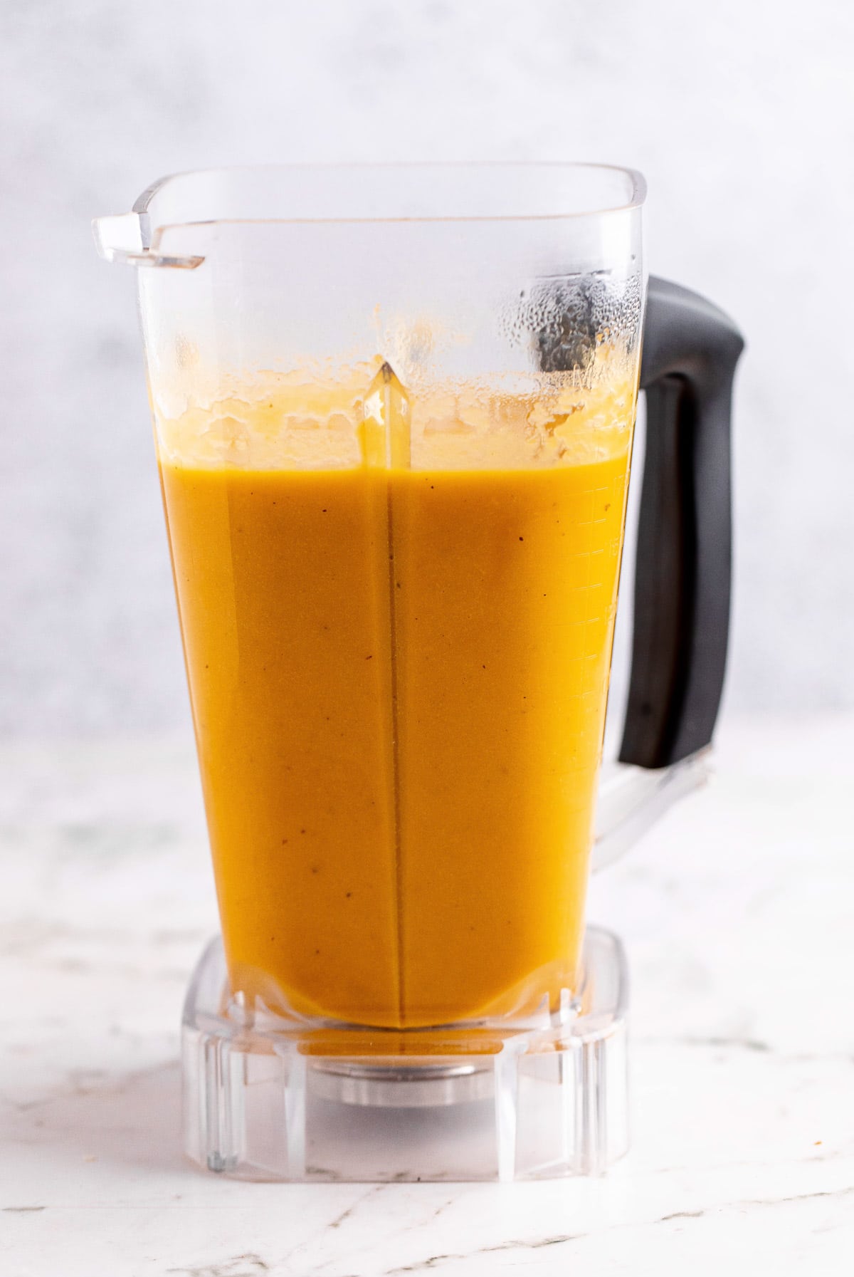 Pureed carrot soup in a blender canister.