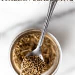A spoon of Italian seasoning on top of a spice jar with text overlay.