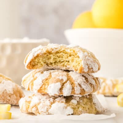 Lemon crinkle cookies with lemons in the background.