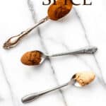 Small spoons of spices to make pumpkin pie spice on a marble background with text overlay.