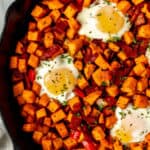 Close up of sweet potato breakfast hash in a cast iron skillet with text overlay.