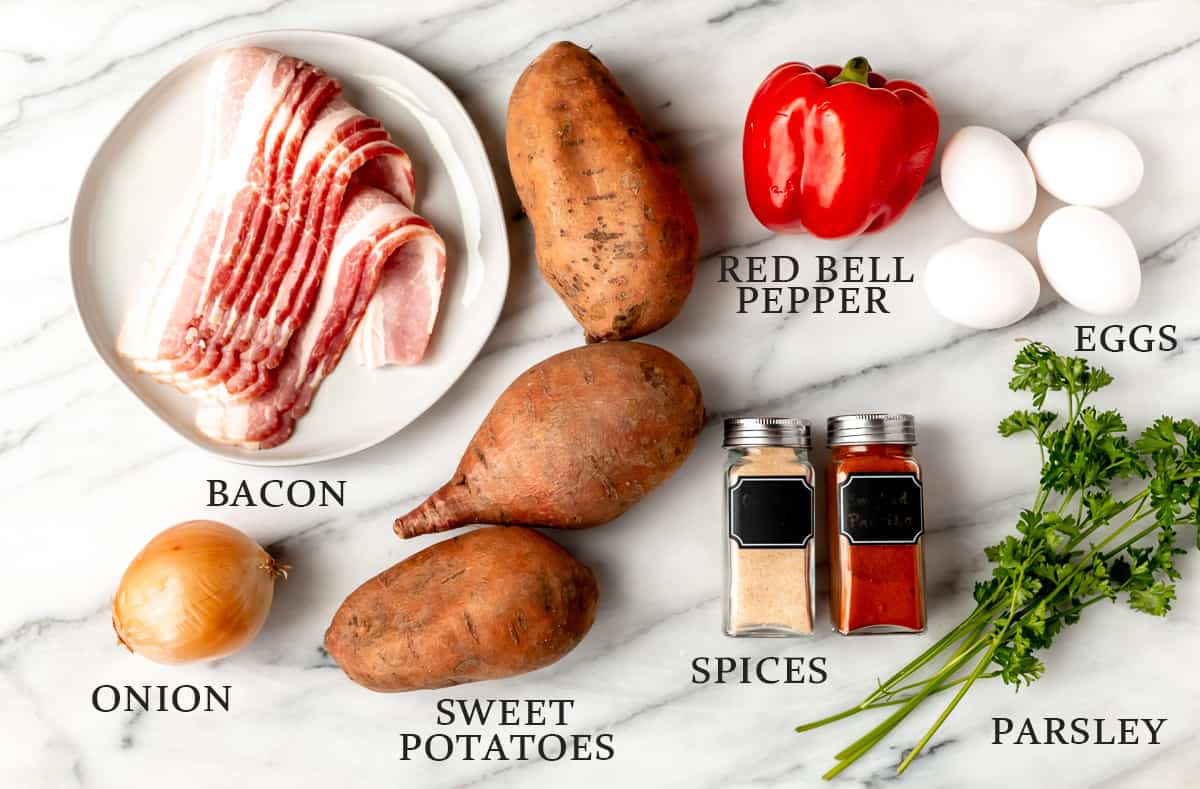 Ingredients needed to make a sweet potato breakfast hash on a marble background with text overlay.