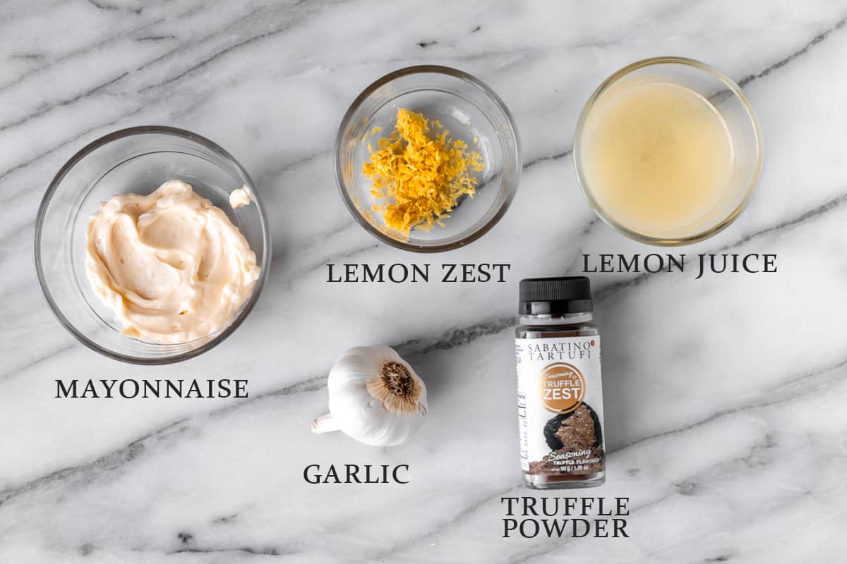 Ingredients needed to. make truffle aioli on a marble background with text overlay.