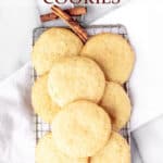 Chai spice snickerdoodle cookies on a cooling rack with cinnamon sticks around it and text overlay.
