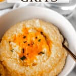 A white bowl filled with cheddar cheese grits and text overlay.