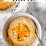 Overhead view of a white bowl filled with cheddar cheese grits and text overlay.