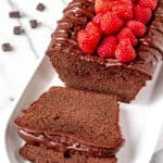 Chocolate pound cake with raspberries on top and text overlay.