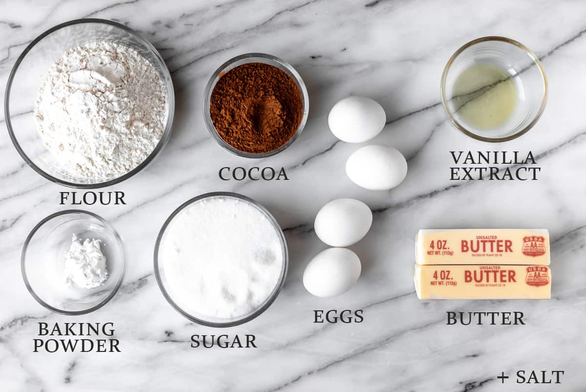 Ingredients needed to make a chocolate pound cake on a marble background with text overlay.