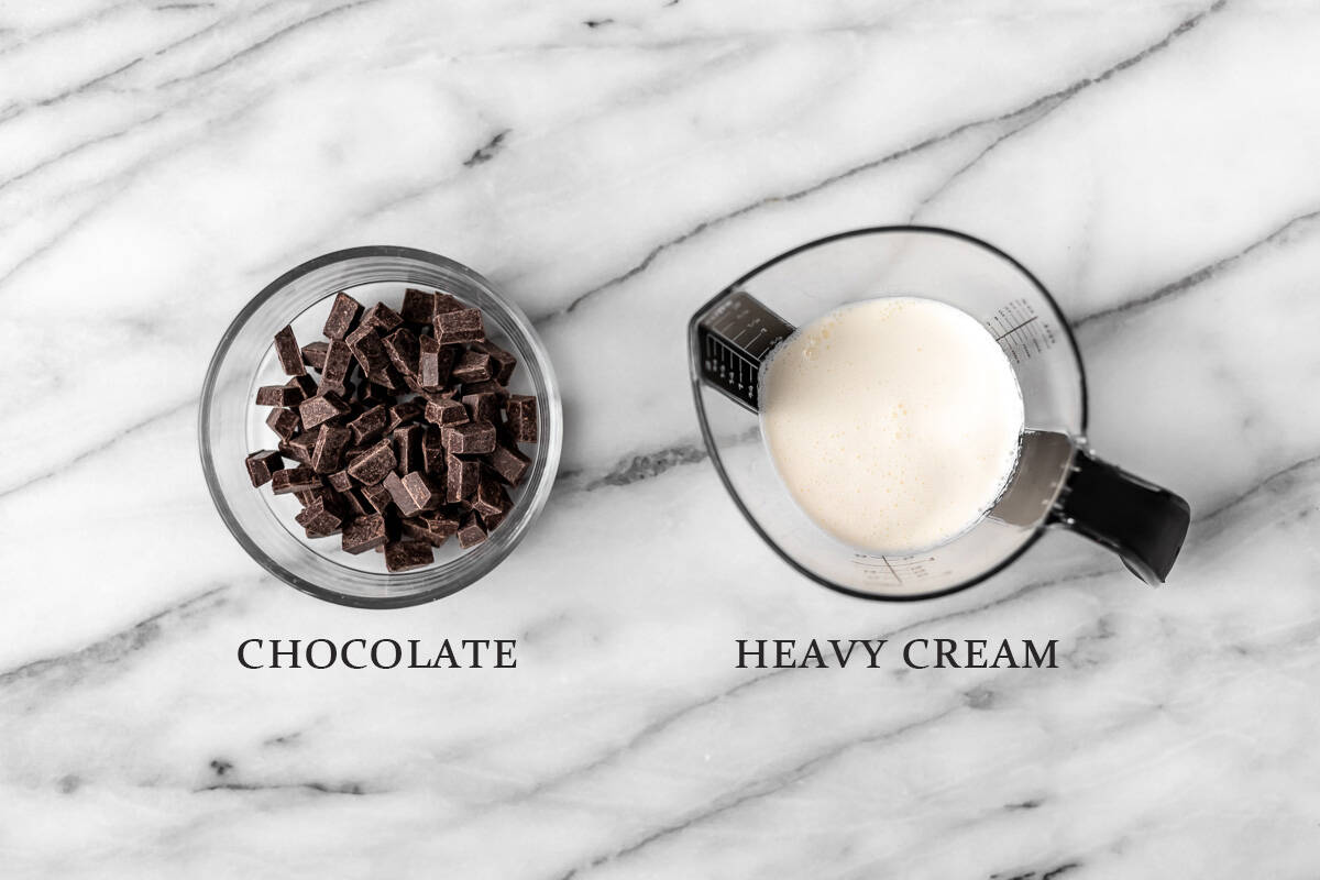 Ingredients needed to make a chocolate ganache drizzle on a marble background with text overlay.