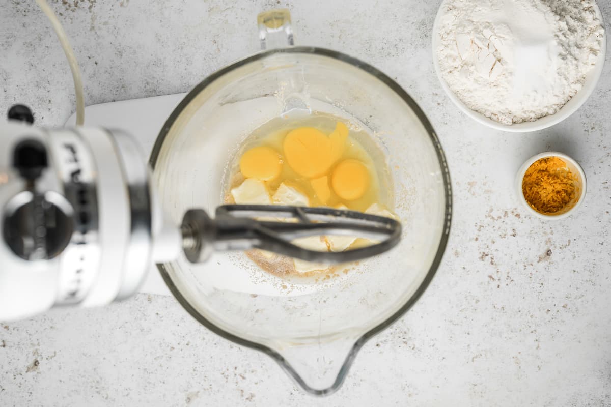 Yeast, butter and eggs in a glass mixing bowl.